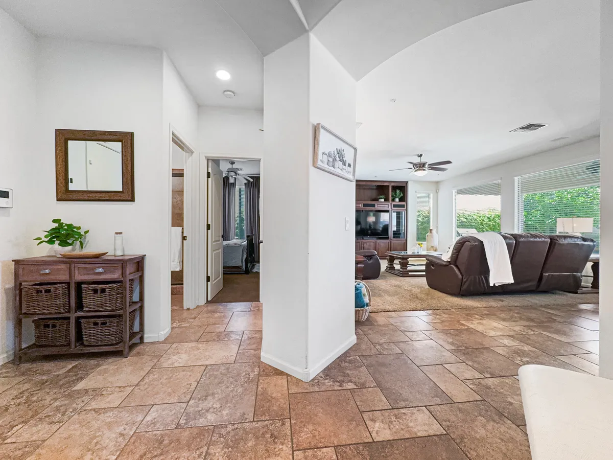 A welcoming entryway flows into a cozy living area, decorated with a stylish mirror and greenery. The scene feels casual and inviting, setting the tone for comfortable daily living and peaceful transitions between work and relaxation.